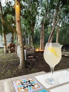 a glass of wine sitting on a table in front of a fire at LA Viella Glamp Tala in Mar del Plata