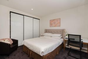 ein Schlafzimmer mit einem Bett, einem Schreibtisch und einem Stuhl in der Unterkunft Spacious 5-Bed Family Home in Giralang in Ginninderra