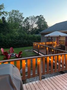 Una terraza con luces, sillas y una sombrilla. en Cozy Cottage In Miller Lake, en Miller Lake