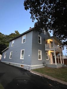 a gray house with a porch and a balcony at 3 Bedroom Apartment on Forestville Bristol in Bristol