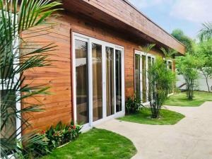 une maison en bois avec de grandes portes coulissantes en verre dans l'établissement Casa Doral Monterrico, à Monterrico 25 autres photos