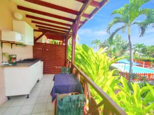 balcón con cocina y vistas a la playa en Maison charmante à Plessis Nogent avec piscine partagée, en Sainte-Rose