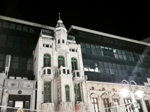 a large white building with a tower in front of a building at Fine apartments Nis in Niš