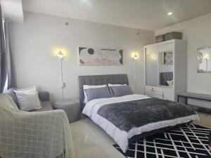um quarto com uma cama grande e um sofá em Style Residences- IML Spaces RM 728 Building B em Iloilo City