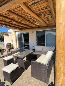 a patio with a couch and a table and chairs at sicilian villa in Mezcales