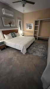 a bedroom with a large bed and a ceiling fan at sicilian villa in Mezcales