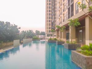 Fully Furnished with Cozy Design 2BR Apartment Transpark Cibubur By Travelio في ديبوك: حمام سباحة في وسط المبنى