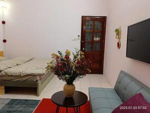 a living room with a vase of flowers on a table at Cactus Homestay 2 in Hanoi