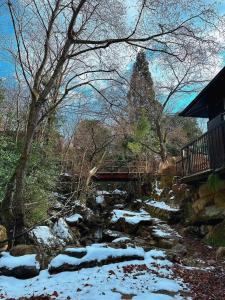 a bridge over a stream with snow on the ground at コテージ遊泊るり渓 in Habu