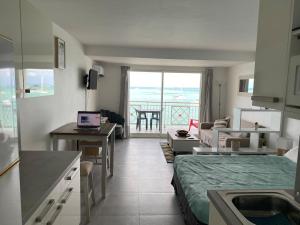 a room with a kitchen and a living room at Beachfront apartment in Marigot