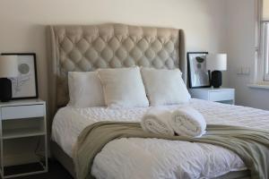 North AdelaideにあるMedindie Home - Close to Adelaide Cityのタオルが敷かれた大きなベッドのある寝室