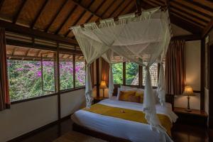 a bedroom with two beds in a room with windows at Temuku Pupuan Farmstay in Padangan