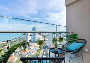 a balcony with chairs and a view of a city at The Sóng Apartment - Căn Hộ Nghỉ Dưỡng - Kim House in Vung Tau