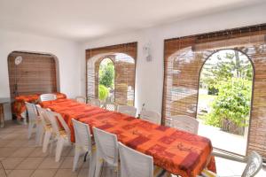 a dining room with a long table and white chairs at Spacious villa with sea view in Trou D'Eau Douce in Trou dʼ Eau Douce
