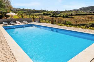 a large swimming pool with blue water in a yard at Charming House in Fornos with shared pool in Fornos