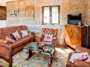 a living room with leather couches and a tv at Charming House in Fornos with shared pool in Fornos