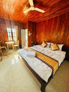 a bedroom with a large bed with a ceiling fan at Residence Boutique Hotel in Luang Prabang +70 photos