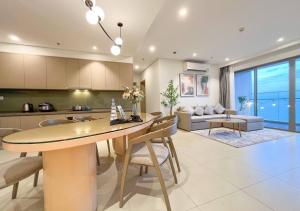 a kitchen and living room with a table and chairs at The Sóng Apartment - Căn Hộ Nghỉ Dưỡng - Kim House in Vung Tau