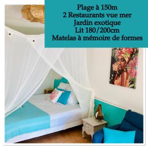 a bedroom with a bed with a canopy at TIKAZADAPH, pour un séjour de charme, romantique & exotique, 97180 Sainte-Anne in Sainte-Anne