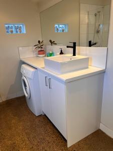 une salle de bain avec un lavabo et une machine à laver dans l'établissement Surfers Palace Torquay 1 min walk to beach, à Torquay 66 autres photos