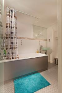 ein Badezimmer mit einer Badewanne, einem Spiegel und einem Teppich in der Unterkunft City Centre Most Central Location - New York Style 2 Double Bedrooms Apartment with 6 Proper Beds - most Central Location by the Xmas Market and Nightlife - Two Bathrooms and Kitchen - Parking for Cars and High Top Vans from Five Pounds a Day in Nottingham