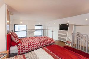 Schlafzimmer mit einem roten Bett und einem Flachbild-TV in der Unterkunft City Centre Most Central Location - New York Style 2 Double Bedrooms Apartment with 6 Proper Beds - most Central Location by the Xmas Market and Nightlife - Two Bathrooms and Kitchen - Parking for Cars and High Top Vans from Five Pounds a Day in Nottingham