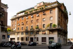 un gran edificio de ladrillo en una calle de la ciudad con coches en Ripense In Trastevere, en Roma