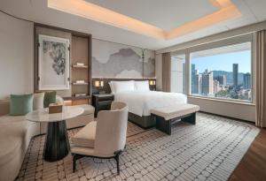 una camera d'albergo con un letto e una grande finestra di The Ritz-Carlton, Shenzhen a Shenzhen