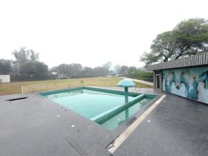 a swimming pool with an umbrella on top of a building at Neelam Orchid in Kānpur