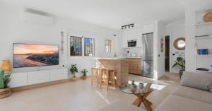 a white living room with a tv on the wall at Penthouse - Beach - Sea View - Pool - 40 sqm Private Terrace - One Bedroom - Sleeping Alcove in Benalmádena