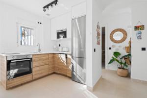 eine Küche mit weißen Wänden und einem Edelstahlkühlschrank in der Unterkunft Penthouse - Beach - Sea View - Pool - 40 sqm Private Terrace - One Bedroom - Sleeping Alcove in Benalmádena