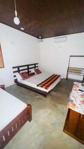 a bedroom with two beds and a table in it at Suriya Cottage Family Resort in Habarana