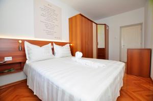 a bedroom with a large white bed with a wooden headboard at Apartment Balcony in Split