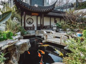 重庆The Boutique Hotel with Authentic Antique Collection & Suzhou Garden的房子前面的锦 ⁇ 池