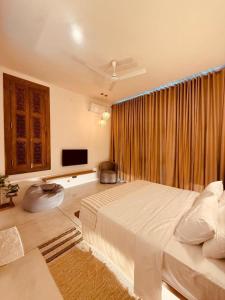 a bedroom with a large bed and a large window at Madiha Venus in Matara