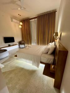 a bedroom with a large bed in front of a window at Madiha Venus in Matara