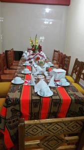 una mesa larga con platos y servilletas. en Vista Waynapata 1 23, en Machu Picchu
