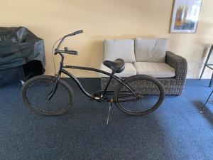 a bike parked in a living room with a couch at Beach Break in Mount Maunganui
