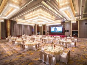ein großer Bankettsaal mit weißen Tischen und Stühlen in der Unterkunft Shantou International Hotel in Changxiacun