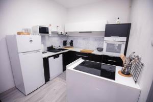 a kitchen with white appliances and black and white cabinets at Apartment Sunshine in Čakovec