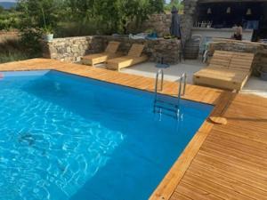 a large blue swimming pool next to a wooden deck at Domaine Saint Augustin in Rieux-Minervois