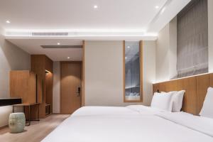 重庆The Boutique Hotel with Authentic Antique Collection & Suzhou Garden的卧室里有一张白色的大床和一张书桌