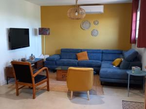 a living room with a blue couch and a chair at Domaine Saint Augustin in Rieux-Minervois