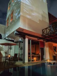 budynek z basenem, stołem i parasolem w obiekcie Cancun Hostel w mieście Cancún