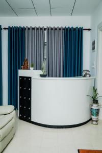 a living room with blue curtains and a table at Villa Baranzio in Tangalle