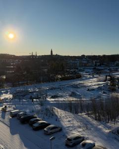 a group of cars parked in a parking lot covered in snow at Cozy Top-Floor Studio in Turku - Near City Center in Turku +3 photos