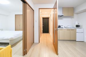 a kitchen and a bedroom with a bed and a kitchen at Shinjuku Raise OG House in Tokyo