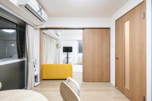 a room with a door and a table and chairs at Shinjuku Raise OG House in Tokyo