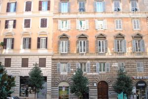 un antiguo edificio en la ciudad con un montón de ventanas en Lombardo, en Roma