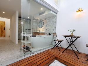 Suzhou Xugusu B&B-Guanqian Street Pingjiang Road Branch في سوتشو: حمام مع حوض استحمام وأرضية خشبية